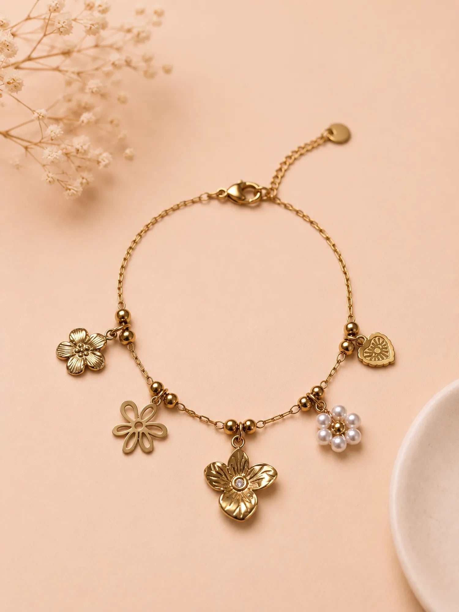 Bracelet doré à charms fleurs et cœur œil rayonnant