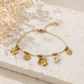 Bracelet doré à charms fleurs, trèfle et cœur œil rayonnant