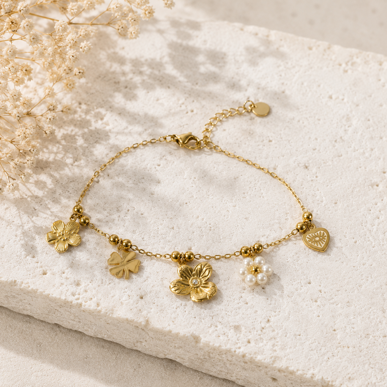 Bracelet doré à charms fleurs, trèfle et cœur œil rayonnant